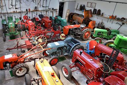 De trekkers in het trekkermuseum van Jan Timmer vormen letterlijk een bont allegaartje. Met de klok mee zien we vanaf linksboven een G&uuml;ldner, een Fahr, een Hela, een Kramer, een Same, een Holder, een Vierzon, een Porsche, een McCormick, een Allis Chalmers en een tweewielige Hummel.