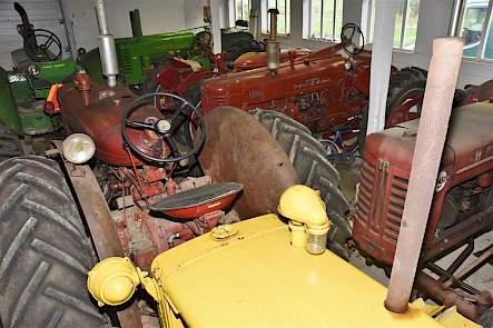 Een andere schuur, andere trekkers. De rode trekker op de voorgrond is een McCormick WD9 Super, de felgele neus is van een Caterpillar D2.