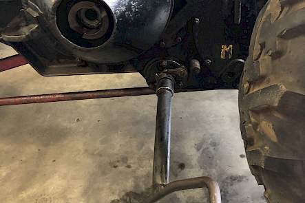 Met deze vleugelmoer kon de trekker met de hand vooruit of achteruit worden gereden. Dat was vooral makkelijk bij spannen van de riem van de poelie naar de dorskast. Eerst moest dan wel de handel boven de slinger van de stand M in de stand H worden gezet. Die letters staan voor respectievelijk motor en hand en wat er mee bedoeld wordt is dat in de M-stand de versnellingsbak aan de motor is gekoppeld en dat hij in de H-stand met de hand kan worden bediend. Ook bij het starten van de trekker moet de versnellingsbak in de H-stand staan, dit om het slingeren te vergemakkelijken.