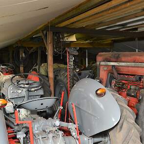 Een schuur vol grijze Fergusons en rode Massey-Fergusons met rechts de grote MF Super 90 uit 1962